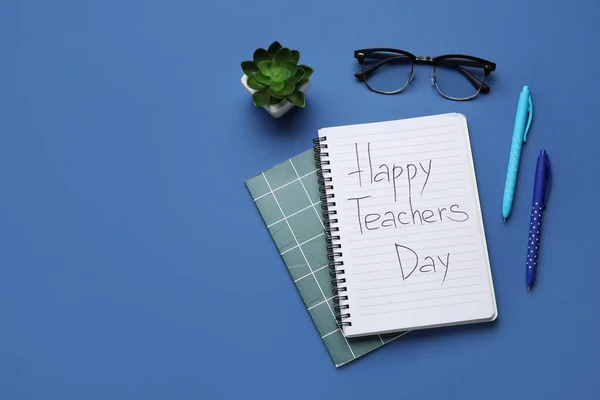 Notebooks with text HAPPY TEACHERS DAY, eyeglasses and houseplant on dark blue background
