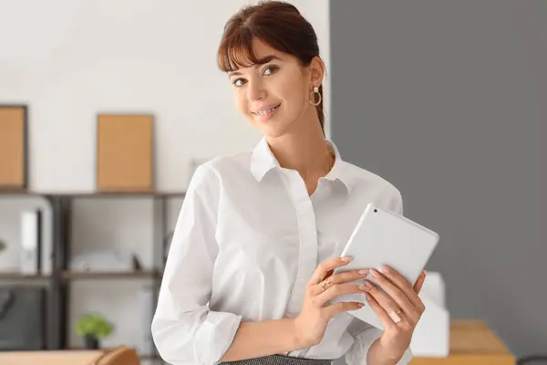 Beautiful businesswoman with tablet computer in office