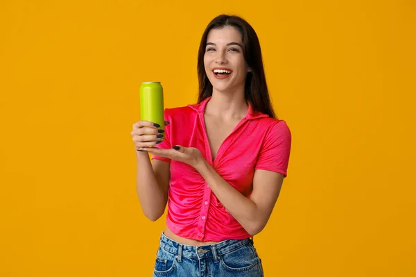 黄色の背景に冷たいビールの缶を持つ美しい若い女性 — ストック写真