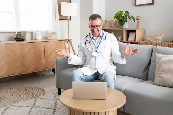 Mature doctor video chatting with patient at home