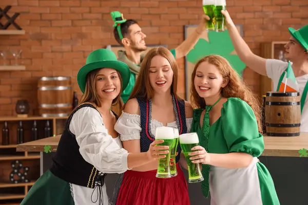Female friends with beer celebrating St. Patrick\'s Day in pub