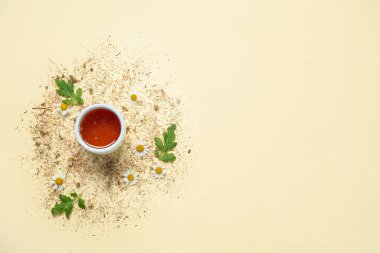 Bir kase ballı kompozisyon, taze ve kurumuş papatya çiçekleri.