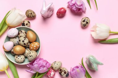 Frame made of Easter quail eggs and tulip flowers on pink background