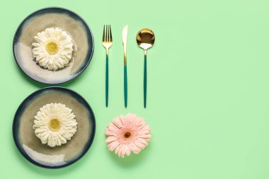 Yeşil arka planda güzel Gerbera çiçekleri olan masa ayarı