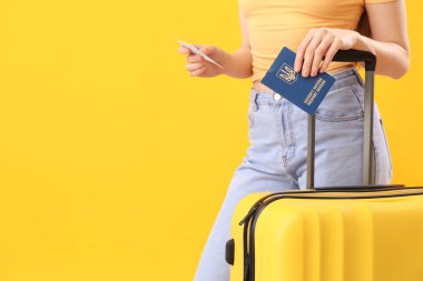 Ukrayna pasaportlu kadın, bilet ve çanta sarı arka planda, yakın plan