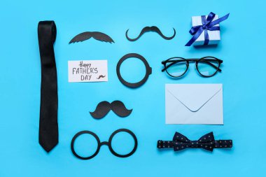Kağıt dekorlu, kravatlı, gözlüklü ve renk arkaplanlı Babalar Günü kutlaması için hediyeli kompozisyon