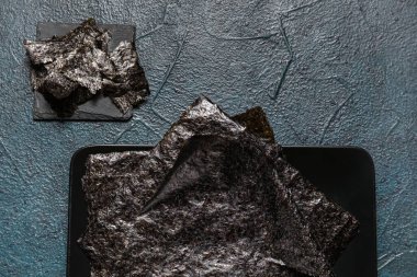 Koyu renk arkaplan üzerinde nori sayfaları olan tabak