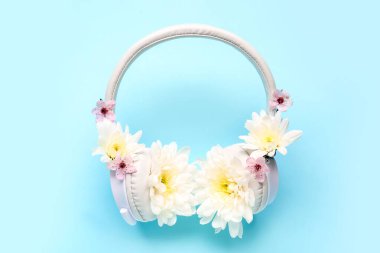 Modern kablosuz kulaklıklar ve renkli arka planda güzel kasımpatı çiçekleri olan kompozisyon