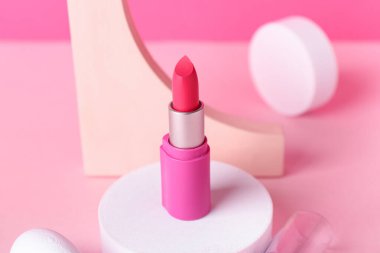 Pembe arka planda dekoratif alçı podyumlar ve ruj.