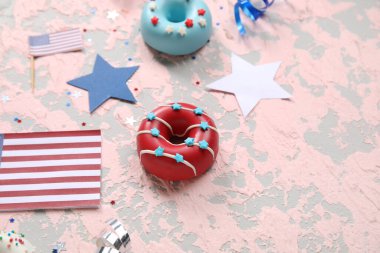 Donutlu kompozisyon, Amerikan bayrakları ve pembe grunge masasında konfeti. Bağımsızlık Günü kutlamaları