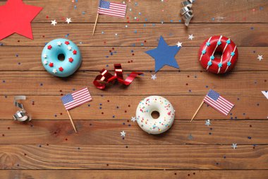 Donutlu kompozisyon, Amerikan bayrakları ve ahşap masada konfeti. Bağımsızlık Günü kutlamaları