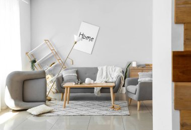 Koltuklu kanepe ve dağınık oturma odasında masa.