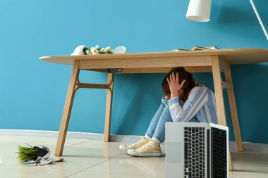 Deprem sırasında masanın altında saklanan genç kadın.