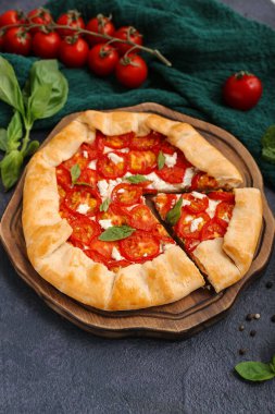 Lezzetli domates galeti ve koyu arkaplanda fesleğen.