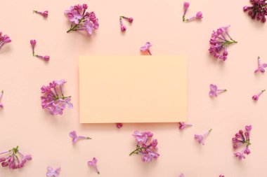 Boş kart ve soluk pembe arka planda güzel leylak çiçekleri.