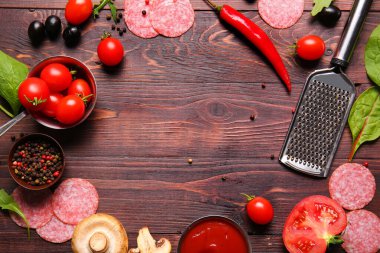 Ahşap zemin üzerinde pizza hazırlamak için taze malzemelerden yapılmış çerçeve