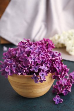 Tahta kase, siyah masada güzel kokulu leylak çiçekleri.