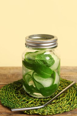 Ahşap masada salatalık dilimleri ile doldurulmuş Mason kavanozu.