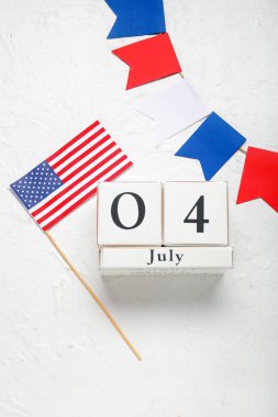 4 Temmuz tarihli küp takvimi, Amerikan bayrağı ve beyaz grunge arka planda renkli çelenk. Bağımsızlık Günü kutlamaları