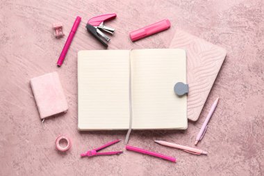 Grunge pembe arkaplan üzerinde farklı kırtasiyeye sahip defterler