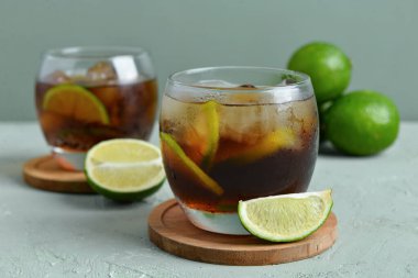 Soğuk Küba kokteyli ve gri arka planda limon.