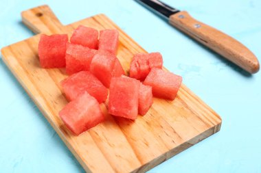 Mavi arka planda taze karpuz parçaları olan tahta