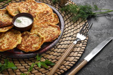 Siyah arka planda ekşi kremalı bir tabak lezzetli kabaklı börek.