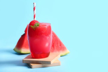 Mavi arka planda bir bardak lezzetli karpuz.