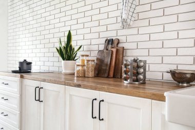 Ahşap tezgah ve çatal bıçaklarla modern mutfağın içinde.