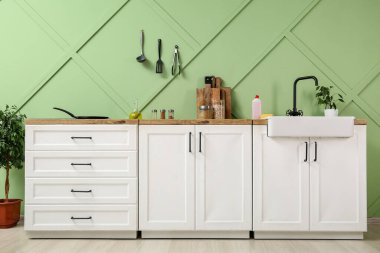 Beyaz tezgahlı, lavabolu ve çatallı modern mutfağın içi.