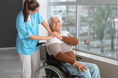 Tekerlekli sandalyedeki kıdemli adam ve hastanede hemşire.
