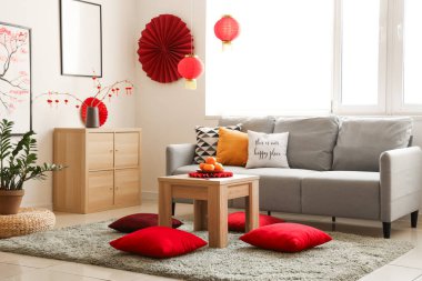 Mandalinalı kahve masası ve şenlikli oturma odasında yerde minderler. Çin Yeni Yıl Kutlaması