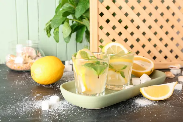 Glasses with fresh lemonade on black table