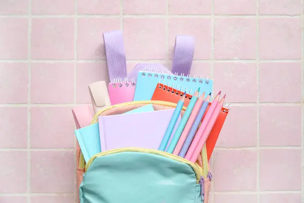 Kolorowy Plecak Szkolny Notatnikami Ołówkami Markerami Różowym Tle Płytek — Zdjęcie stockowe