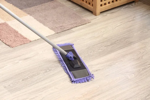Cleaning of grey laminate floor with mop