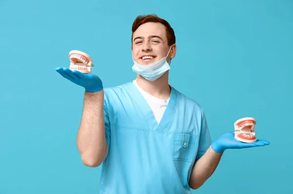 Männlicher Zahnarzt Mit Kiefermodellen Auf Blauem Hintergrund Weltzahnärztetag — Stockfoto