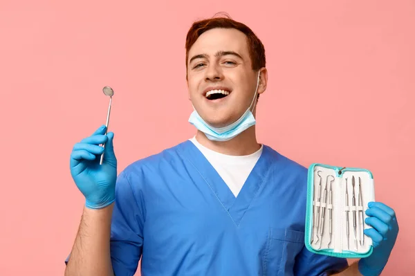 Männlicher Zahnarzt Mit Einer Reihe Von Zahnwerkzeugen Auf Rosa Hintergrund — Stockfoto