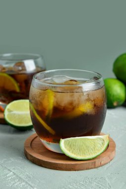 Soğuk Küba kokteyli ve gri arka planda limon.