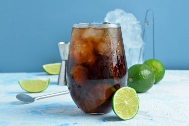 Mavi arka planda soğuk Küba Libre kokteyli.