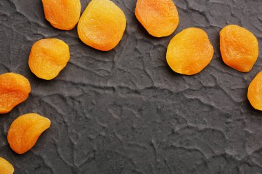 Tasty dried apricots on black background