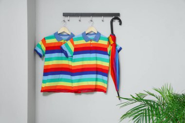 Koridordaki ışık duvarında asılı gökkuşağı tişörtleri