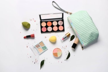 Beyaz arkaplanda makyaj ürünleri bulunan şık kozmetik çanta