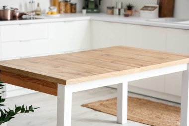 Modern mutfağın içindeki temiz ahşap masa.