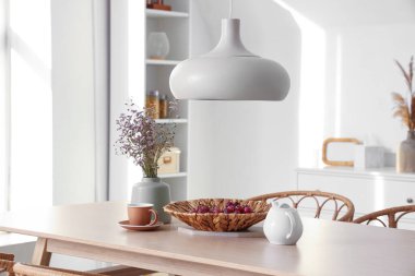 Hafif odada kurutulmuş lavanta, üzüm ve çay bulunan yemek masası.