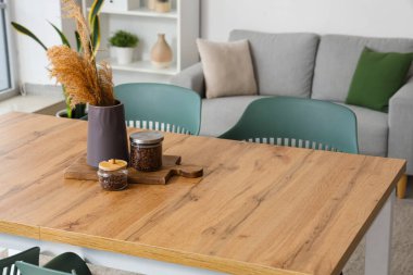 Kahve çekirdekli kavanozlar ve yemek masasında otlar.