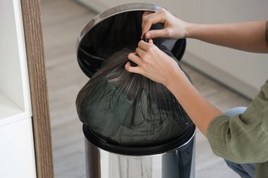 Mutfaktaki çöp kutusuna çöp böceği atan kadın, yakın plan.