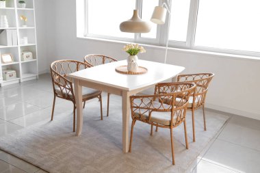 Işık odasındaki yemek masasında güzel lale çiçekleri olan vazo.