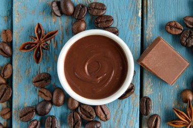 Mavi ahşap arka planda lezzetli eritilmiş çikolatalı kompozisyon