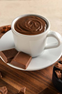 Beyaz ahşap arka planda erimiş çikolatalı bir fincan.