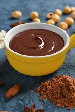 Mavi arka planda lezzetli erimiş çikolatalı kase.